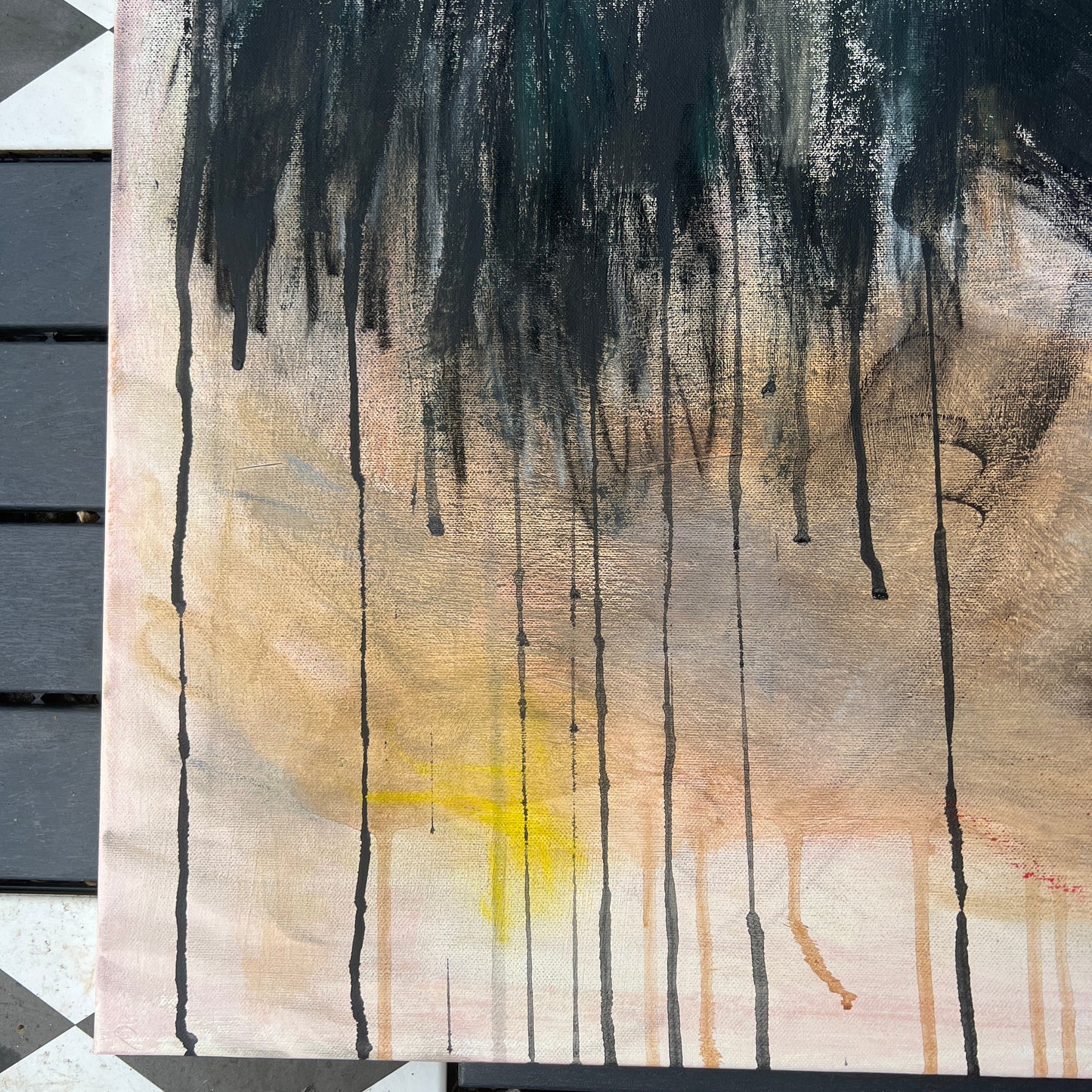 Abstract art piece with black, brown, and yellow colors on a textured surface.