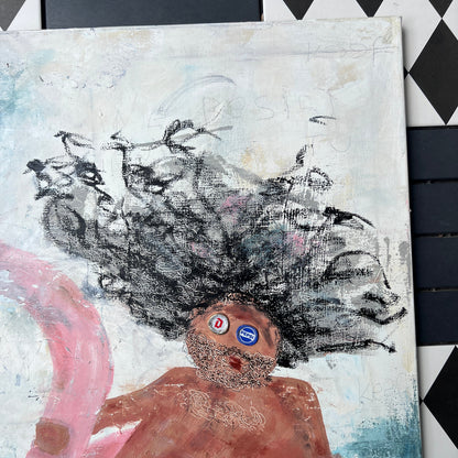 A square canvas painting featuring an expressive childlike figure with large black hair, a brown body, blue and white striped shorts, and pink flowing shapes, photographed against a black-and-white diamond-patterned surface.