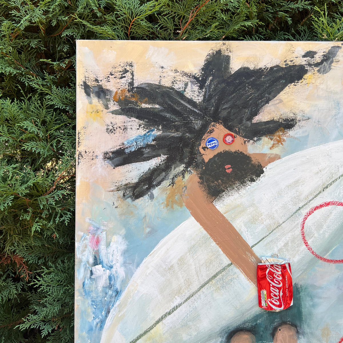 An abstract painting depicting a figure with black hair holding a white surfboard, styled on a canvas and photographed outdoors against a background of green pine branches. The painting features a red Coca-Cola can graphic.