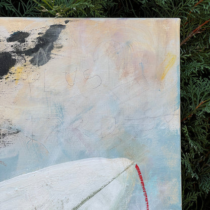 An abstract canvas painting with textured brushstrokes of white, light blue, beige, black, and a small red accent, photographed outdoors against green foliage.