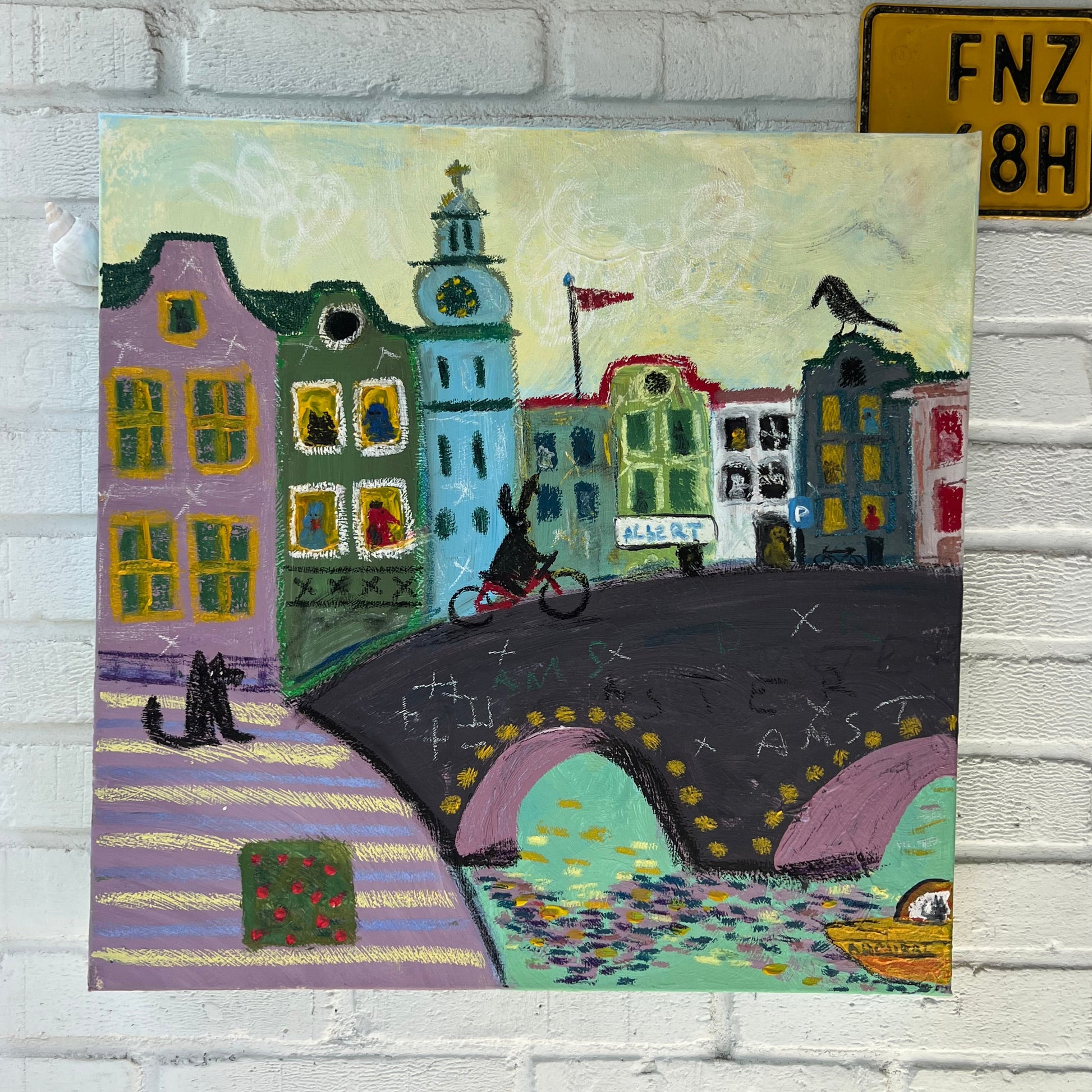 Colorful painting of a cityscape on a textured white wall with small decorative items.