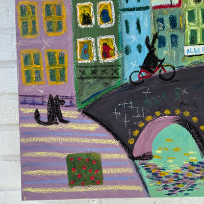 Colorful rug with abstract design of houses and trees on a white brick wall.