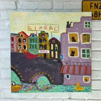 Colorful rug with artistic design of buildings on a white brick wall.